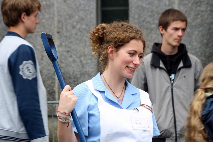 woman in white and blue collared shirt holding blue stick